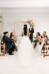 Beautiful bride in a chic dress goes to the altar