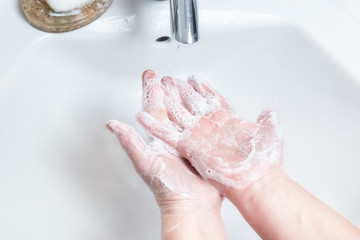 Fototapeta premium Washing hands with soap under the faucet with water