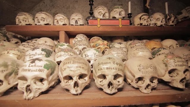 Hallstatt, Austria Skulls painted with names, colorful flowers and crosses in the Charnel House or Beinhaus, Hallstatt, Austria