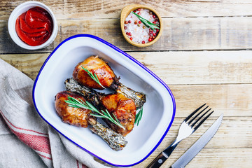 Grilled chicken drumstick bbq with rosemary on a rustic wooden background.
