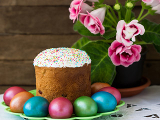 Easter  cake, multi-colored eggs  and  pink gloxinia the rustic table.