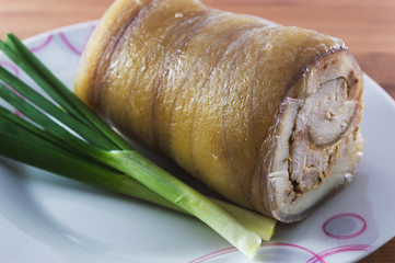 Raw turkey meatloaf on table, marinated with spices and herbs on a wooden plate.