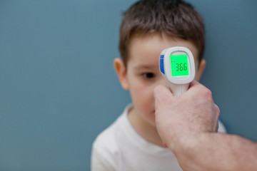 using infrared thermometer to measure child's body temperature