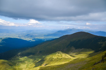 Naklejka premium Picturesque mountain slopes, green valleys, beautiful landscape of the Svydovets ridge against a cloudy sky. Ukraine