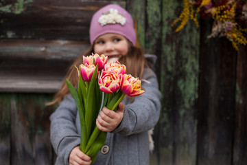 little girl with bouquet  of spring flowers tulips.march 8 ,mother's day concept
