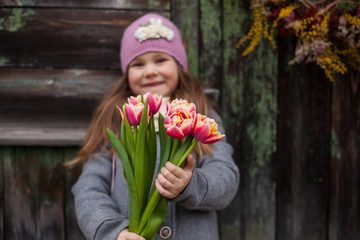 little girl with bouquet  of spring flowers tulips.march 8 ,mother's day concept