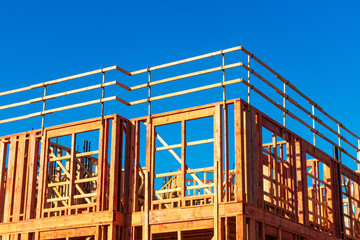 New residential wood framed building construction under blue sky