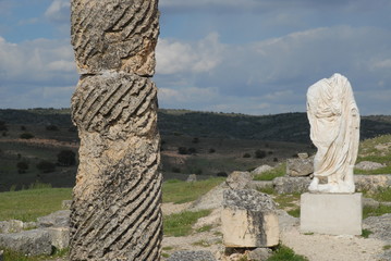 Carved stone column and headless Roman statue wearing a toga, Segobriga, near Saelices, Cuenca Province, Castile-La Mancha, Spain