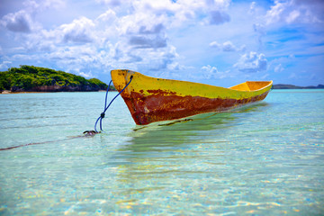 Fisherman canoe on a pristine water under a blue sky  and crazy clouds
