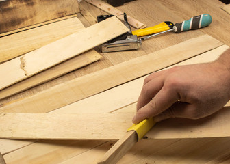 Man hands processes the board with sandpaper