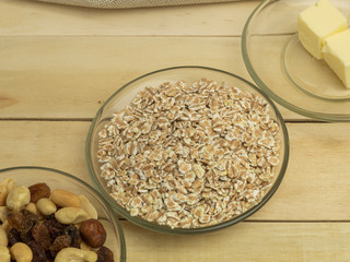 Oatmeal flakes, a mixture of nuts and butter on a wooden background