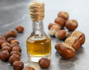 Oil in a bottle and nuts on a marble background