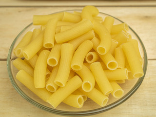 Pasta in a glass plate on a wooden background