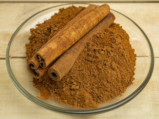 Spice cinnamon powder topping for baking in a glass plate on a wooden background