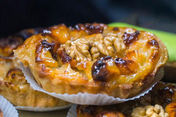 Delicious fresh shortcrust tart cake with cream and walnut for sale on counter of shop, grocery, market, cafe or bakery. Dessert, sweet food and confectionery concept