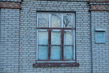 one large old wooden window on a gray brick wall of a building