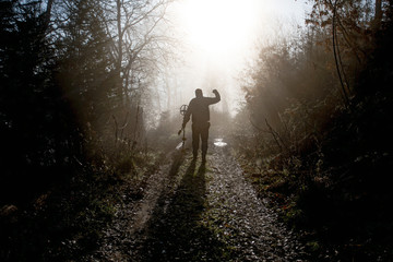 Obraz premium Man searching treasure in the wood with metal detector at sunrise in autumn. Success concept