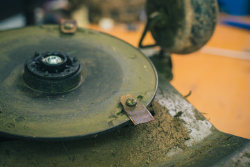 Old cutting blades on motorized robotic lawnmower. dirty and rusty lawnmover blade ready to be...