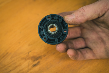 Old blade disc bearing on motorized robotic lawnmower. dirty and rusty lawnmover blade ready to be...