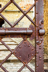 Old weathered rusty metal door at the Forte di San Leo or Fortress of San Leo in the Province of Rimini, Region of Emilia-Romagna, Italy, close partial view