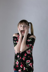 Young girl looking surprised on studio backgrround