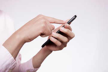 woman hands using a cell phone on pink background