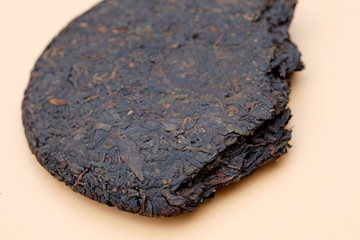 Pressed Puer tea in the form of pancake. Slice of pancake pressed Chinese tea. Dry leaves of black puer.