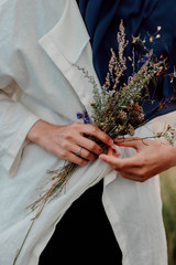 White wildflowers in the hands of a girl on the field