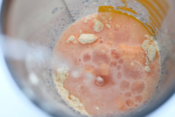 Water is poured into a blender bowl to make a cocktail. Protein shake in a shaker. Powder sports nutrition.