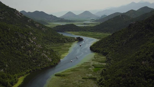 Tourist boat on River Crnojevica in Skadar Lake National Park, Montenegro. seen from Pavlova Strana panoramic lookout. Summer tourism & family travel destination in Balkans Europe