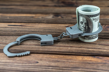 Money dollars bundle in handcuffs. Crime, bribe, theft