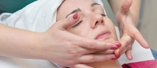 Obraz na płótnie Canvas Face skin care. Beautician applying beauty oil mask on face using brush In spa salon