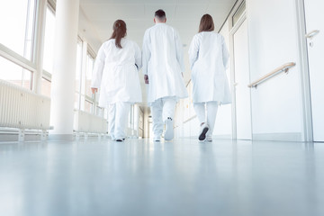 Three doctors walking down a corridor in hospital