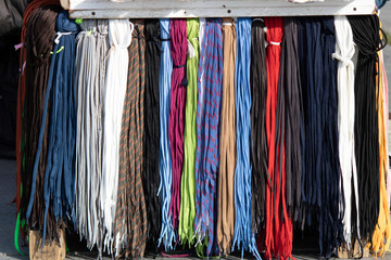 Hanging shoe laces have different colors and varieties. Close up.