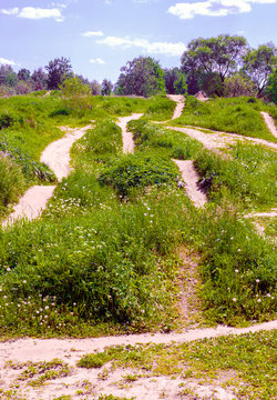 Lots of different tracks on green hills on summer sunny day