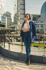 Fototapeta premium Office buildings city people in suit. Caucasian businesswoman using smartphone with hand. Business concept. Portrait stylish business woman in fashionable clothes holding Phone near office building