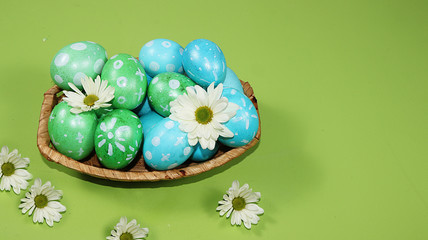 Decorated golden and blue eggs on a trendy green background. Minimal holiday concept. Happy Easter background, place for text, postcard, banner for the screen.
