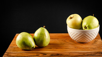 apples in a bowl on wooden table
