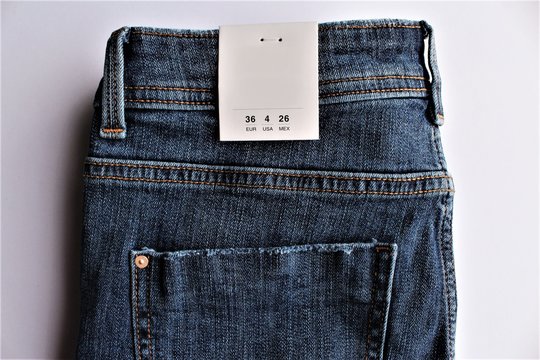 Blue jeans with a size tag photo isolate on white background top view