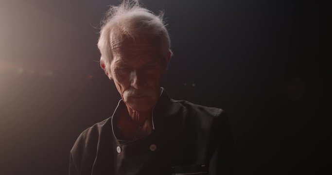 Experienced elderly caucasian chef is putting flour and kneading dough, using traditional recipes, pensioneer enjoying his hobby after retirement, isolated on black background 4k footage