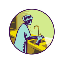 Retro woodcut style illustration of a female doctor, health professional or nurse wearing surgical mask spraying disinfectant spray on sink viewed from side set in circle on isolated background.
