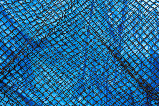 Detail of commercial fish net covering blue tarpaulin,Seattle
