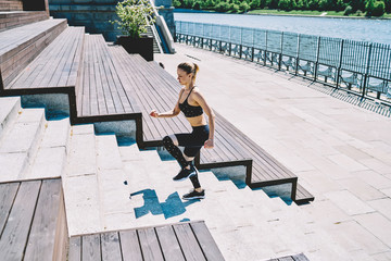 Concentrated lady doing fitness exercise on seafront