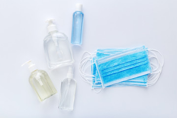 Coronavirus protection. Medical protective surgical masks, hand sanitizer bottles on white table. Alcohol gel antibacterial soap sanitizer, hands disinfection. Hygiene protection Coronavirus Covid 19