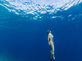 Sportive woman snorkeling in water of sea