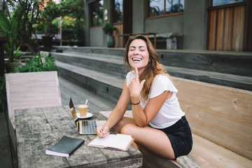 Beautiful cheerful woman making notes with eyes closed