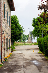 San Leo street view with a stray ginger cat and the war memorial in the background, in San Leo, Province of Rimini, Region of Emilia-Romagna, Italy