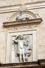 Fototapeta na wymiar Saint Michael sculpture over the entrance of the Church of San Michele and Arch of Augustus Museum in Fano, Province of Pesaro and Urbino, Marche Region, Italy
