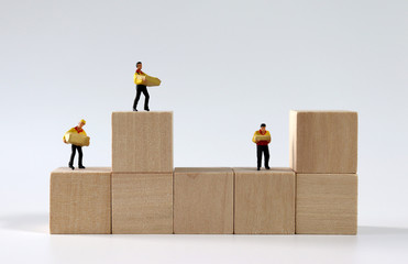 Miniature courier drivers standing on wooden blocks.