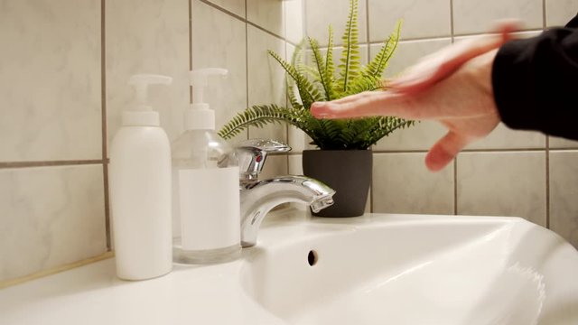 male sanitizes hands with liquid sanitizer 